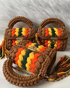 Detailed view of handmade crochet bags with vibrant striped patterns and metal hardware