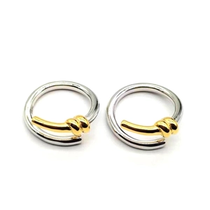 Detail of S925 sterling silver twisted rope hoop earrings with gold contrast knot design