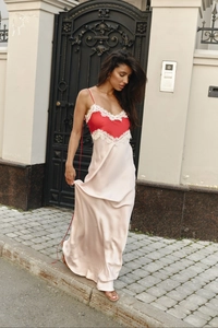 Detail of red satin bodice with white lace trim on a long champagne slip dress