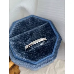 Silver ring engraved with Je t'aime in a blue velvet box on white fabric