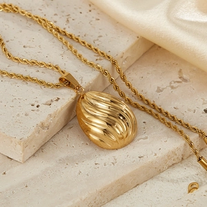 Elegant gold stainless steel necklace with textured oval pendant on vintage rope chain