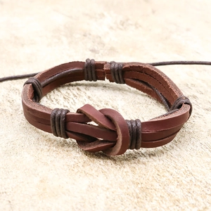 Handmade brown leather wrap bracelet with infinity knot design on a neutral stone background