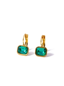 Detailed close-up of golden square earrings featuring emerald green faceted zircon stones