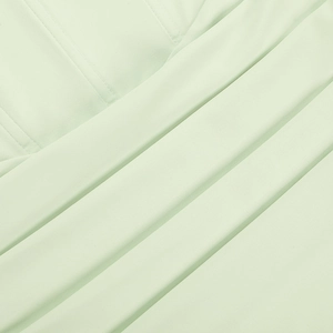 Gros plan détaillé des coutures et des plis du tissu sur une robe moulante vert clair
