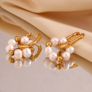Vue macro de boucles d'oreilles en U plaquées or 18K avec perles sur de la soie