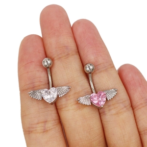 Vue macro de piercings de nombril en zircon en forme de cœur avec ailes en métal