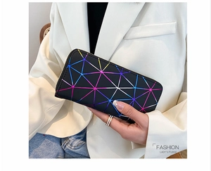 Detail of laser geometric pattern and gold zipper on a long wallet held by a woman
