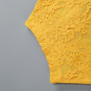 Dettaglio in primo piano di pizzo floreale giallo brillante con ricami traforati