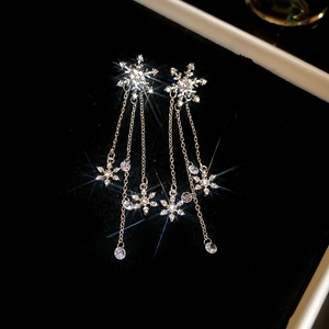 Detailed view of elegant silver snowflake tassel earrings with sparkling rhinestones