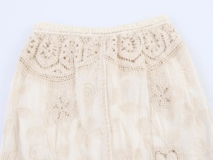 Detalle de la cintura de ganchillo bohemio y bordado floral en falda de playa color beige