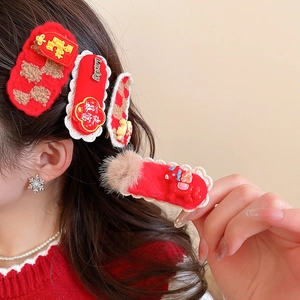 Détail d'un ensemble de barrettes en peluche rouge avec breloques sur un mannequin