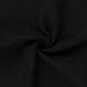 Vista dettagliata del tessuto jacquard nero con elegante trama a spirale e pieghe