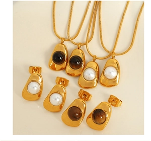 Detailed flat lay of gold jewelry sets with white pearls and brown gemstones