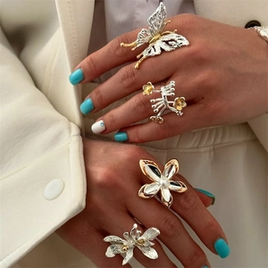 Close-up of vintage butterfly and floral rings in gold and silver finish with pearls