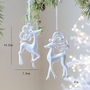 White flocked reindeer Christmas ornaments with silver glitter hanging on pine tree branches