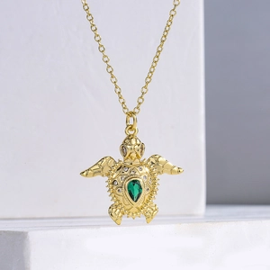 Collana con ciondolo a tartaruga dorata con cristallo verde e dettagli scintillanti