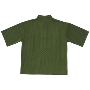 Detail of army green knit shirt showing intricate diamond jacquard pattern and texture