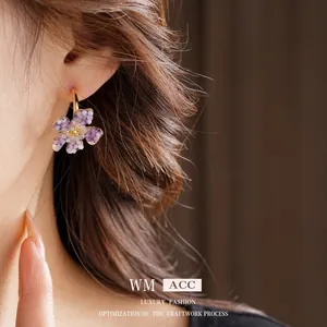 Vintage flower C-shape earrings with purple beads and crystal center on model