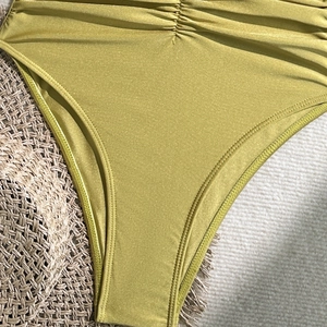 Detail of olive green ribbed swimsuit fabric with ruching and high-quality stitching