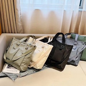 Waterproof nylon tote bags in four colors with adjustable straps and front pockets
