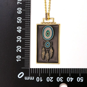 Detailed size measurement of the black dreamcatcher feather pendant with ruler