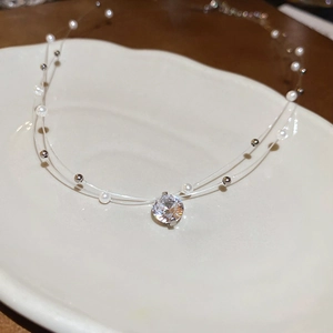 Detail of double-layer necklace with pearl beads and round zircon pendant on white tray