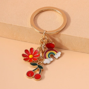Colorful oil-drip keychain featuring floral, cherry, and rainbow charms on a gold ring