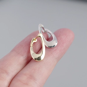 Macro shot showing hollow teardrop metal earrings in gold and silver finish
