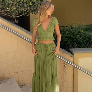 Détail d'un crop top vert en mousseline avec dentelle et jupe longue sur un mannequin