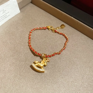 Dettaglio ravvicinato del ciondolo a cavallo a dondolo placcato oro 24K con zirconi su cordino