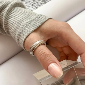 Minimalist 925 sterling silver twill ring worn by model showing glossy metallic texture