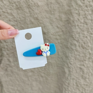 Detailansicht der blauen Haarklammer mit Hello Kitty und roten Herzverzierungen
