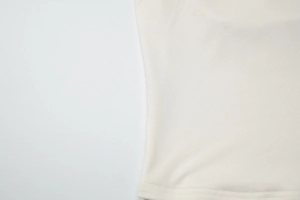 Gros plan sur la texture du tricot et les coutures de l'ourlet du haut licou crème