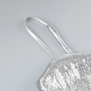 Macro shot of silver sequins dress with adjustable shoulder straps and fine stitching