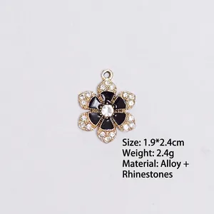 Detail view of black enamel flower charm with inlaid rhinestones measuring 1.9x2.4cm