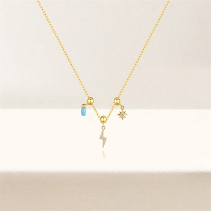 Detail of s925 silver gold-plated necklace with turquoise, lightning, and star charms