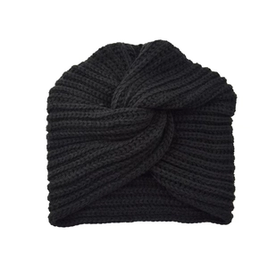 Detail view of black knit turban hat featuring a signature cross-knot design and ribbed texture