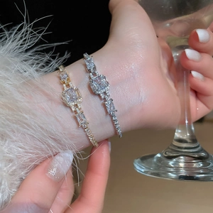Macro detail of luxurious interlocking gold and silver bracelets with square cubic zirconia