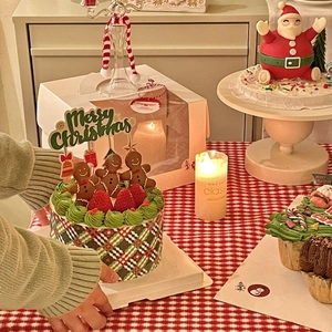 Close-up of Christmas cake with gingerbread man topper and Merry Christmas gold stamping