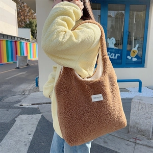 Detailed texture of brown sherpa fleece tote bag with minimalist white brand label