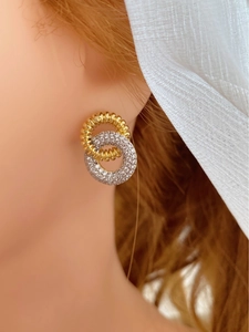 Close-up of dual-layer intertwined gold textured and silver zircon-studded hoop earrings