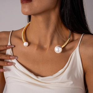 Detailed close-up of a golden spiral metal choker featuring large white imitation pearls