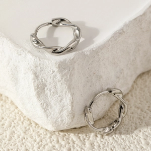 Minimalistische silberne Mobius-Ohrringe mit gedrehtem geometrischem Design auf Stein