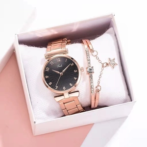 Detailed view of rose gold women's watch with black dial and matching star charm bracelet