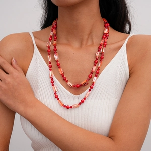 Close-up of double-layer beaded necklace with red rounds and iridescent shell slices