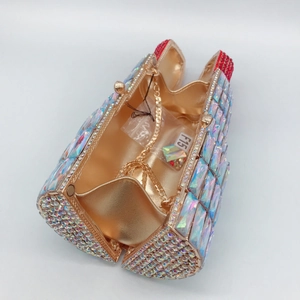 Lipstick-shaped evening clutch featuring iridescent rhinestones and golden interior detail