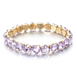 Detailed view of elastic gold bracelet featuring continuous purple heart-cut zircons