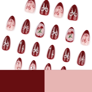 Almond press-on nails with cherry, bow, and heart designs in wine red and pink