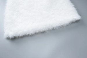 Close-up detail of soft white faux fur fabric showing fluffy texture and plush fibers