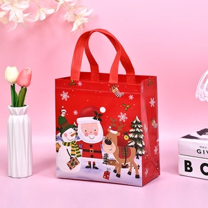 Christmas non-woven gift bag with Santa and reindeer prints on a warm red background